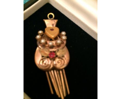 A pretty Victorian pendant, probably for a marriage, it is modelled as&nbsp;two hearts and a horseshoe. One Ruby chip set to 