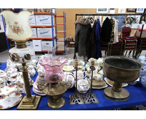 A reeded gilt column oil lamp, a brass oil lamp with cranberry shade, a pair of candlesticks and a brass jardiniere on pedest