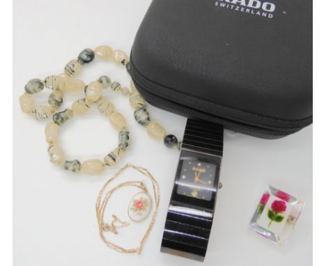A ladies Rado Jubile, a 9ct pendant and chain, carved lucite brooch and beads Condition Report: The glass appears clouded mig