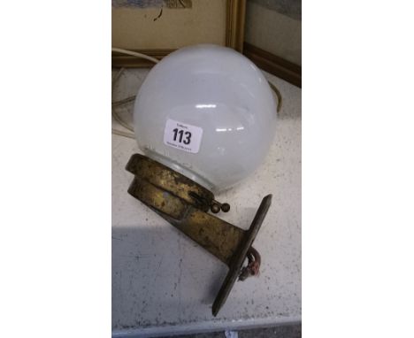 An art deco iron wall light fitting with globular opaque white glass shade.