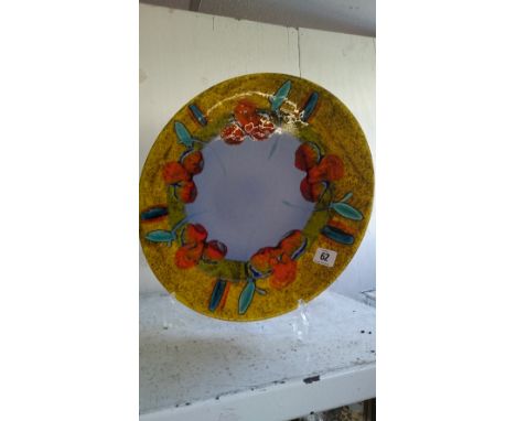 A modern Poole Pottery Studio charger decorated in vivid tones of orange, green, blue and green in a stylized Iris design (H4