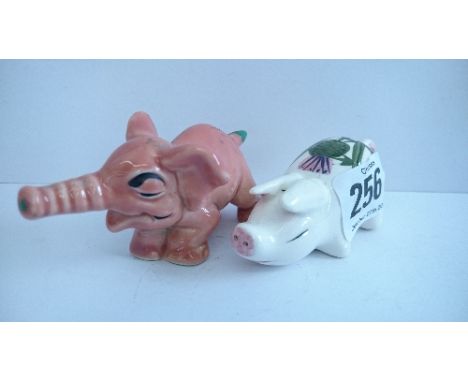 A miniature Plichta Wemyss style china Pig decorated with a Thistle together with a Wade china model of a miniature pink elep