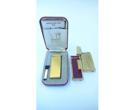 A Dunhill gold plated engine turned cigarette lighter in original presentation case together with two other Dunhill cigarette