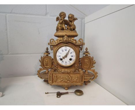 A late 19th Century French gilt ormolu mantel clock with Roman numeral hours and Arabic minutes. The case surmounted by cheru