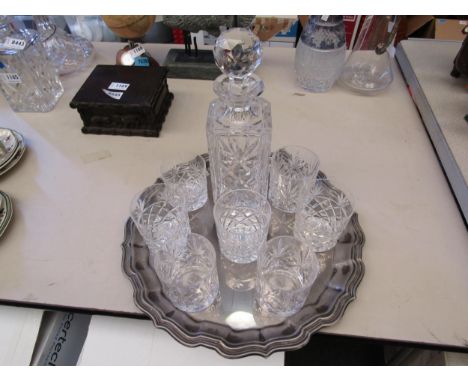 A crystal glass decanter and seven glasses on a plated tray 