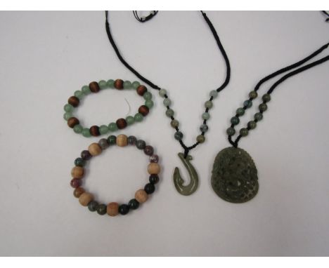 A carved jade dragon pendant, two bracelets and a necklace 
