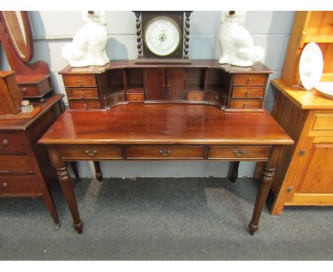 A late Victorian/Edwardian mahogany Mansion House desk with fitted structure of drawers, cupboard and pigeon holes, the three