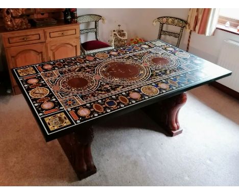 An Indian hardstone-inlaid pietra dura tabletop of oblong form on carved wooden supports, 80h x 183 w x 102 d x 4 cm, in good