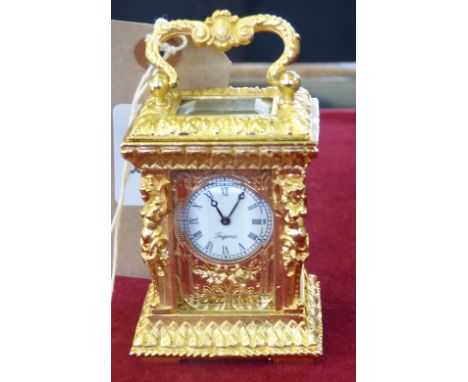 A cast gilt metal carriage style clock with keywind movement, 10cm high