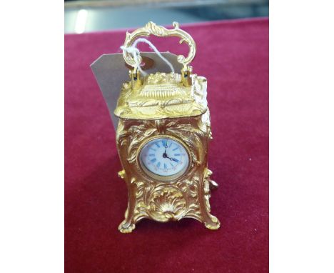 A cast gilt metal carriage style clock with keywind movement, 10cm high