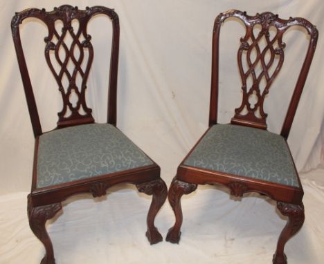 A set of four reproduction mahogany Chippendale-style dining chairs with pierced vase splat-backs and upholstered seats on ca