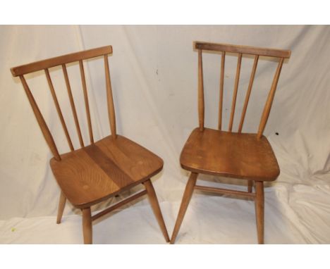 A set of four 1960's Ercol light elm dining chairs with spindle-backs and shaped seats on turned legs