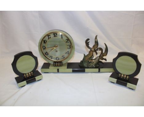 A 1930's French Art Deco mantel clock garniture comprising an onyx mounted black slate mantel clock with circular dial flanke