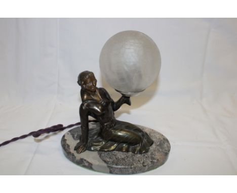 An Art Deco bronzed spelter table lamp in the form of a kneeling female holding an opaque glass sphere on oval marble base, 8