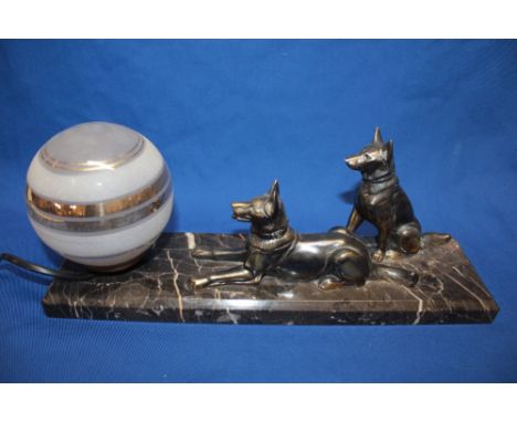 An Art Deco table lamp in the form of two Alsatian dogs before a glass sphere on rectangular marble base, 13½" long