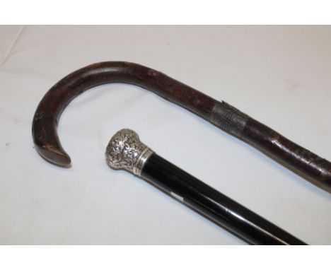 A gentleman's ebonised walking cane with silver mounted top, Birmingham marks and one other silver mounted rustic walking sti