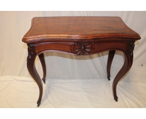 A 19th century walnut shaped-rectangular turnover-top card table with baize lined playing surface on scroll-shaped legs with 