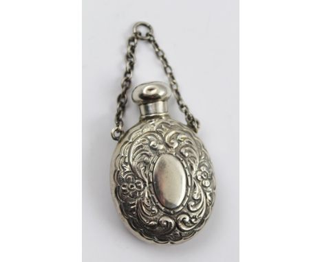 GEORGE UNITE A SILVER SCENT FLASK of oval form with screw cap and chain handle, embossed floral and acanthus leaf decoration,