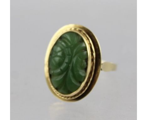 A 14CT GOLD AND JADE RING, with central oval carved jade stone set in stepped mount on plain shank, stamped "585", size P 