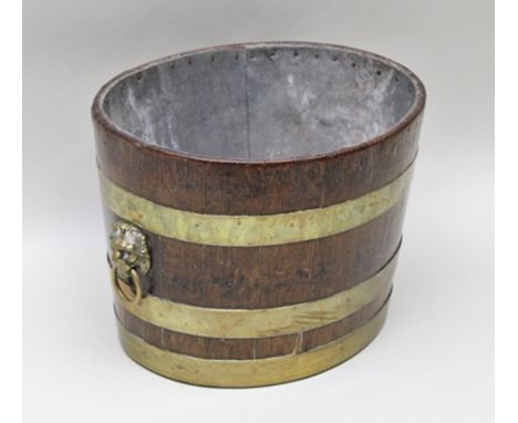 A 19TH CENTURY COOPERED HALF BARREL with triple brass banding and lion mask ring drop handles, having metal liner suitable fo