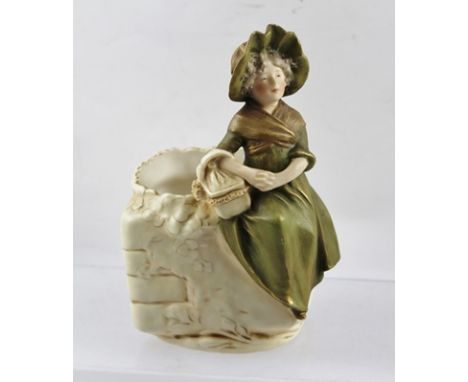 ROYAL DUX OF BOHEMIA A CERAMIC BOWL, upon the edge is modelled a girl in 19th century costume, with a basket, painted in the 