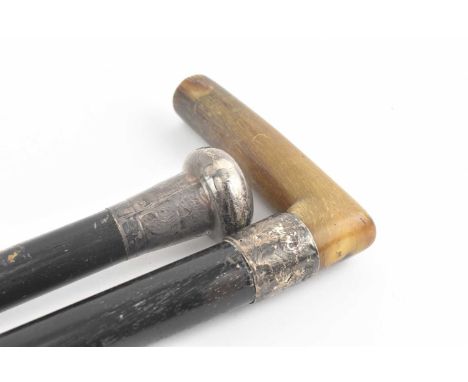 Two late 19th - early 20th century silver topped ebonised walking sticks. The lot comprising a cane with silver knob top, hal