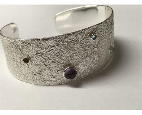 Sterling silver textured open cuff bangle set with cabochon amethyst and faceted blue topaz, citrine & peridot 