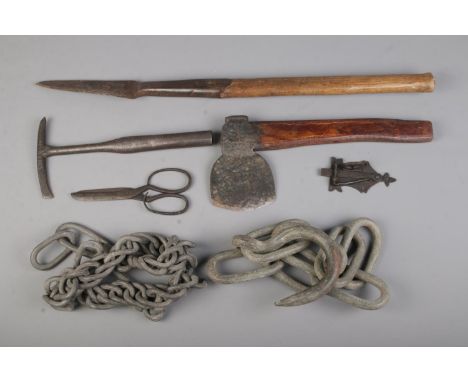 A small collection of antique tools including cutters, scissors, axe, chain etc  