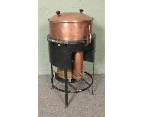 A military copper stove/dispenser bearing broad arrow mark to lid and lower paraffin burner stove. Possibly a copper still.  