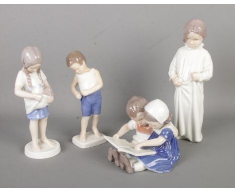 Four Bing and Grondahl ceramic figure groups; Boy 1759, Girl with Kitten 1779, Children Reading 1567 and Girl in a Nightdress