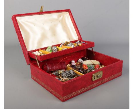 A red cantilever jewellery box, containing a collection of costume jewellery. Includes articulated fish pendant, floral bangl