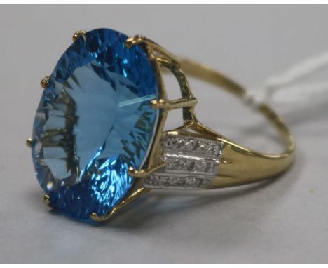 A 9ct gold and fancy cut blue topaz dress ring with diamond set shoulders, size Q.