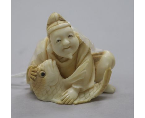 A carved ivory netsuke of a man with fish