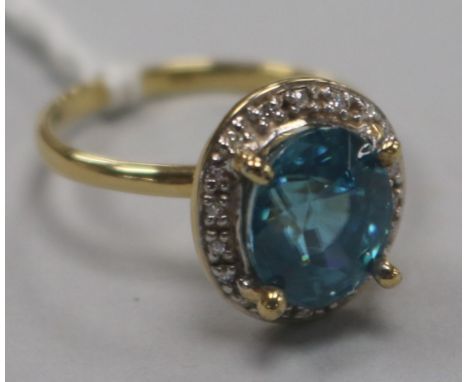 A 9ct gold, blue zircon and diamond set oval cluster ring, size N.