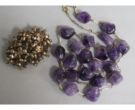 An amethyst pebble bead necklace and a Christian Dior brooch signed and numbered 1960, with original box and pouch.