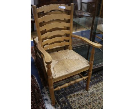 A set of eight early 20th century oak ladder back cottage dining chairs, with rush seats, including two carvers