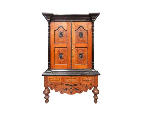 A 19th-century style Sri Lankan ebony and padauk wood cabinet, 20th century, with moulded cornice above a pair of shaped pane