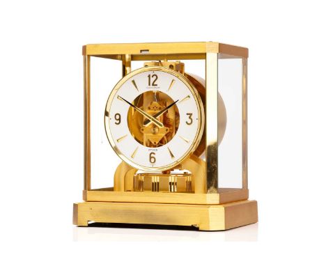 A Jaeger LeCoultre brushed brass Atmos clock, no. 453672, with Arabic numerals at the quarter chapters, lacking front glass p