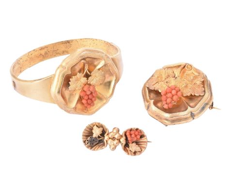 Y A Victorian coral and gold bangle and brooch suite, the hinged bangle with a quatrefoil shaped panel with applied vine leaf