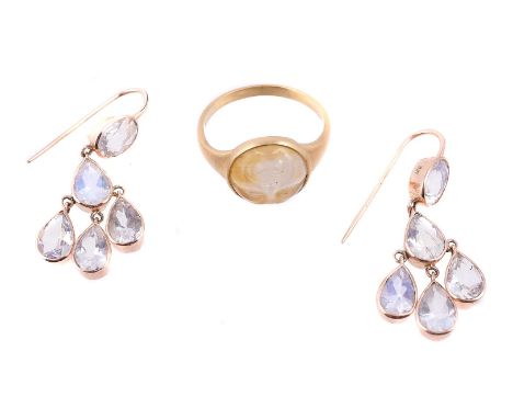 A novelty moonstone ring, the circular moonstone carved as the moons face, 11mm diameter, to a matt finish tapered shank, fin