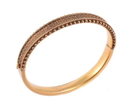 A mid 19th century gold Etruscan style bangle, circa 1870, the front panel with beaded and ropetwist decoration, stamped 15ct