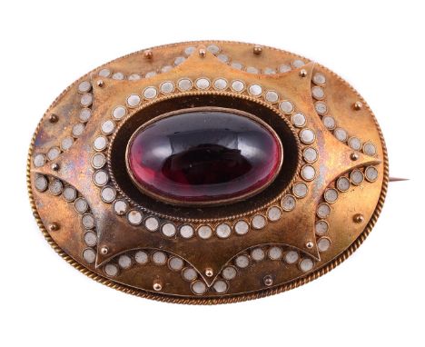 A mid Victorian garnet and enamel oval brooch, circa 1870, the central oval cabochon garnet within a gold surround with white