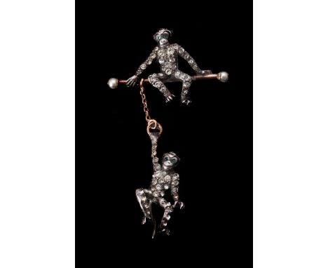 A late Victorian paste monkey brooch, circa 1900, the first monkey pavé set with circular cut white pastes, with green paste 