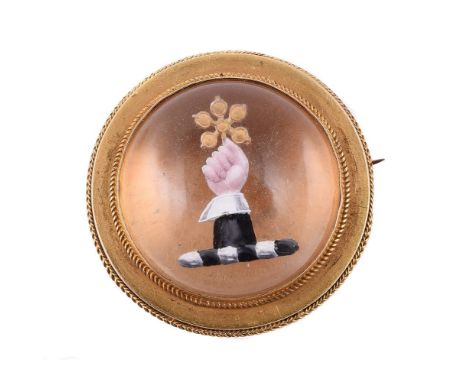 A late Victorian reverse painted intaglio brooch, circa 1880, the circular cabochon rock crystal carved with a white cuffed h