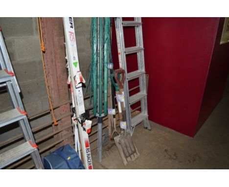A rotary washing line together with a quantity of long handle gardening tools