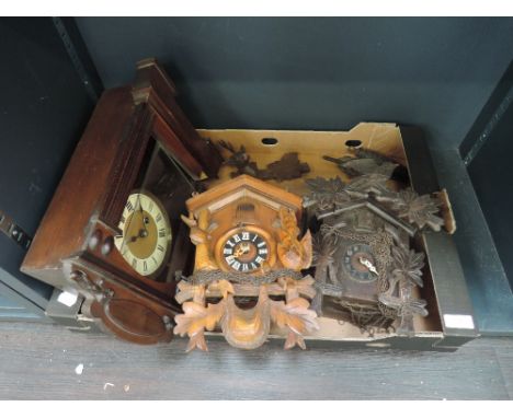 Two traditional Swiss cuckoo clocks and an early 20th century stained frame mantel clock