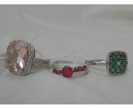 Three dress rings including emerald style square cluster, ruby style stone with set diagonal shoulders and a large cluster on