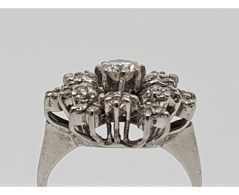 An 18ct. white gold diamond cluster ring, set single round brilliant cut diamond to centre with numerous single cut diamonds 