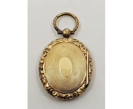 A Victorian yellow metal double oval locket, engine-turned with pinchbeck frame.