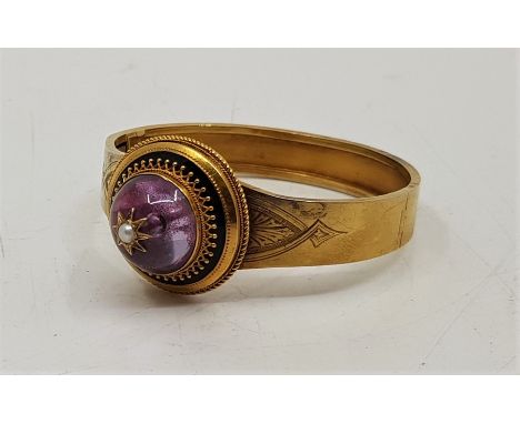 A 19th century precious yellow metal, black enamel and rock crystal set hinged bangle, the front having large domed foil back